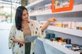 asian shopkeeper arranging the liquid stock at the shelf