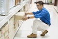 Asian shopper man picking cardboard from hyper market shelf in warehouse Royalty Free Stock Photo