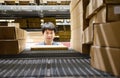 Asian shopper man standing between cardboard box shelves in warehouse choosing what to buy. shopping warehousing or packing Royalty Free Stock Photo