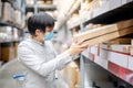 Asian shopper picking cardboard box in warehouse