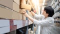 Asian shopper picking cardboard box in warehouse Royalty Free Stock Photo