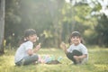 Asian sibling planting young tree on black soil together as save world in garden on summer day. Planting tree. Childchood and