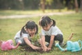 Asian sibling planting young tree on black soil together as save world in garden on summer day. Planting tree. Childchood and