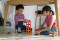 Asian sibling playing building block while sitting in a blanket fort in living room at home for perfect hideout away from their Royalty Free Stock Photo