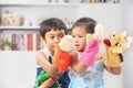 Asian sibling playing hand puppet