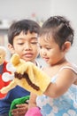 Asian sibling playing hand puppet