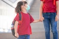 Asian siblings of primary school go hand in hand. sister and girl with backpack behind the back. Beginning of lessons. First day Royalty Free Stock Photo