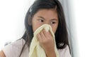 Asian sick girl using handkerchief at home