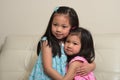 Asian sisters hugging and smiling