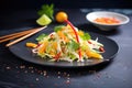 asian slaw with mandarin slices, black slate background