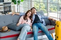 Asian sleepy male female couple traveler with hat and sunglasses sitting sleeping together on sofa in living room with trolley Royalty Free Stock Photo