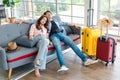 Asian sleepy male female couple traveler with hat and sunglasses sitting sleeping together on sofa in living room with trolley Royalty Free Stock Photo