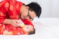 Asian smart young father feed his adorable son baby in bed  healthy fatherhood happy play with infant while feeding both father Royalty Free Stock Photo