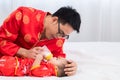 Asian smart young father feed his adorable son baby in bed  healthy fatherhood happy play with infant while feeding both father Royalty Free Stock Photo