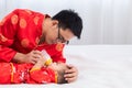 Asian smart young father feed his adorable son baby in bed  healthy fatherhood happy play with infant while feeding both father Royalty Free Stock Photo