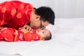 Asian smart young father feed his adorable son baby in bed  healthy fatherhood happy play with infant while feeding both father Royalty Free Stock Photo