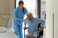 Asian smiling nurse helping senior man get out of bed nursing care support patient while getting out of bed and moving to Royalty Free Stock Photo