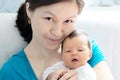 Asian smiling woman holding infant baby in her arms, happy motherhood Royalty Free Stock Photo