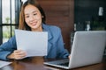 young business woman reading report document compare with laptop computer Royalty Free Stock Photo