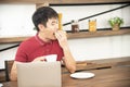 Asian smiling young man with casual  red t-shirt enjoy having breakfast Royalty Free Stock Photo