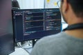 Asian software developers working on multiple screens displaying code and application diagrams in a modern office
