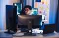 Asian software developers working on multiple screens displaying code and application diagrams at night in modern office
