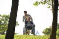 Asian son and wheelchair bound father enjoying nature