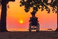 Wheelchair on the sea beach with sunset on travel time in holiday family and learning about nature around the sea Royalty Free Stock Photo