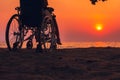 Wheelchair on the sea beach with sunset on travel time in holiday family and learning about nature around the sea Royalty Free Stock Photo