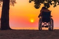 Asian special child on wheelchair on the sea beach with sunset Royalty Free Stock Photo