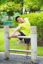 Asian sport boy stretching on iron bar in garden Royalty Free Stock Photo