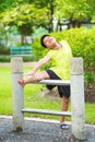 Asian sport boy stretching on iron bar in garden Royalty Free Stock Photo
