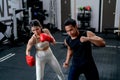 Asian sport trainer man help woman to practice with boxing for good action and movement in fitness gym