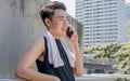 Asian sportive man talking on mobile phone outdoor