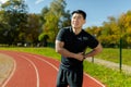 Asian sportsman has severe pain in back and abdominal muscles, man peed training in stadium on sunny day massaging side