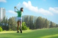 Asian  Sporty woman golfer player doing golf swing tee off on the green, people presumably does exercise. Royalty Free Stock Photo