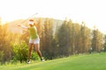 Asian Sporty woman golfer player doing golf swing tee off on the green, people presumably does exercise. Healthy Sport Royalty Free Stock Photo