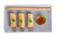 Asian spring rolls and sauce on white background