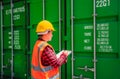 Asian staff woman in yellow safety helmet and checking containers box stock