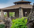 Asian stone gazebo with grass roof and hanging lanterns