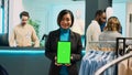 Asian store assistant using greenscreen display on tablet