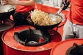 Asian street food festival in city. Chef cooking noodles and vegetables in a pan on fire. Fried chinese japanese noodles with Royalty Free Stock Photo