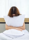 Asian stressed depressed worried upset sad frowning face young female model sitting alone under white blanket holding hands Royalty Free Stock Photo