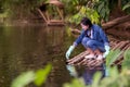 Asian student biology taking and testing sample of natural river water. Royalty Free Stock Photo