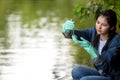 Asian student biology taking and testing sample of natural river water. Royalty Free Stock Photo