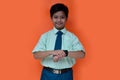 asian student boy looking watch, isolated ata orange background. Royalty Free Stock Photo