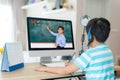 Asian  student boy video conference e-learning with teacher on computer in living room at home. E-learning ,online ,education and Royalty Free Stock Photo