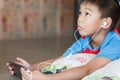 Asian student child boy using and touching smart pad or tablet for do his homework and online learning E-learning. Royalty Free Stock Photo