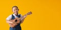 Asian student cute little girl wears school uniform playing ukulele Royalty Free Stock Photo