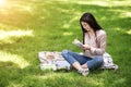 Asian student girl preparing for exams in park, writing notes to notepad Royalty Free Stock Photo